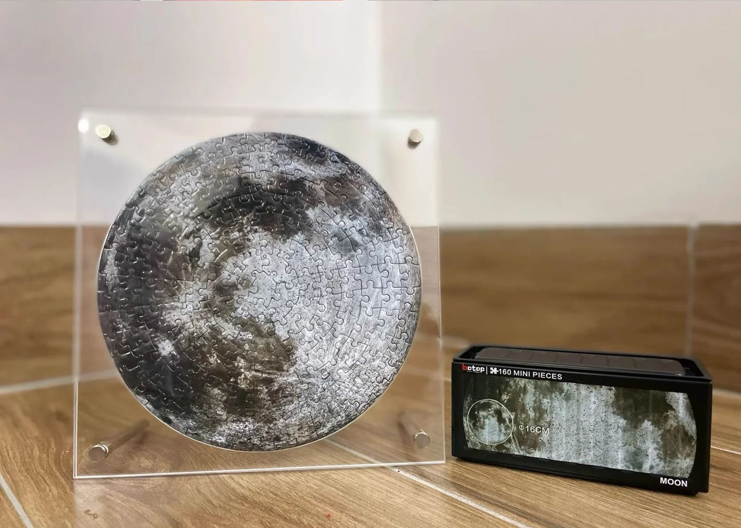 Round moon puzzle in acrylic frame shown beside matching Botop puzzle box.