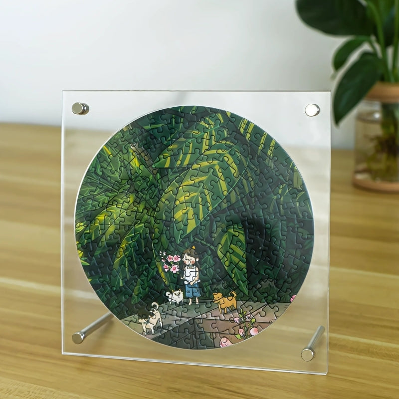 Acrylic square frame holding round puzzle of girl and dogs in lush green jungle path.