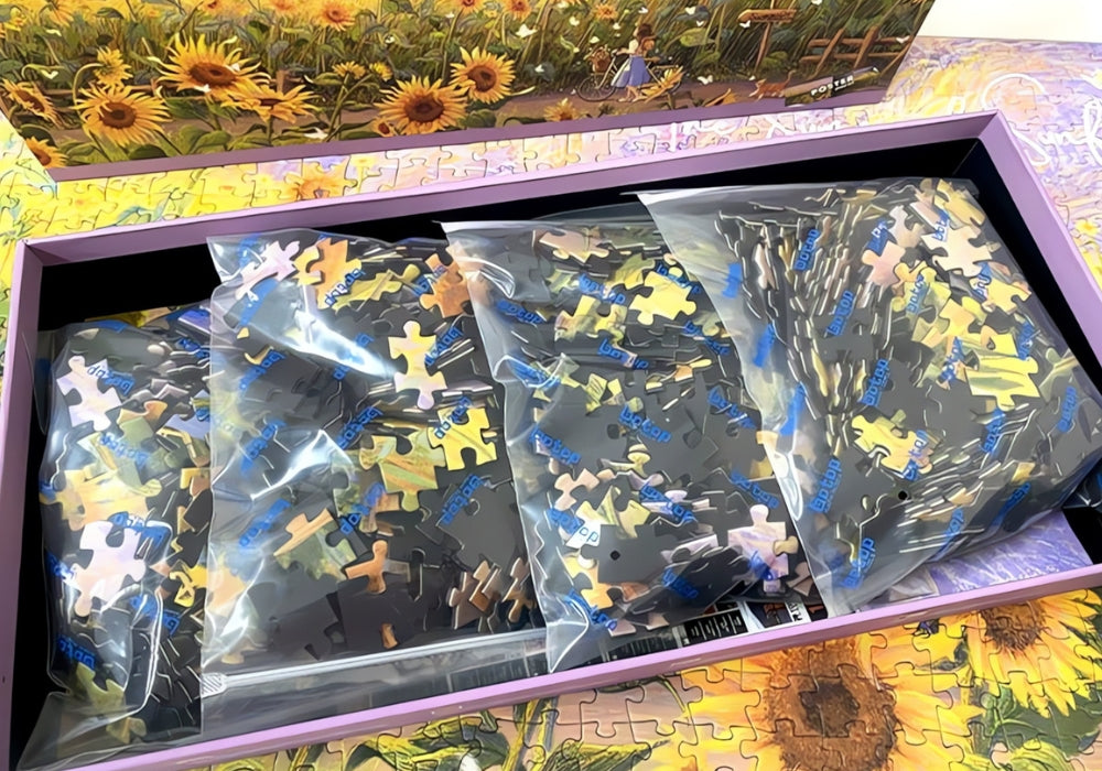Open puzzle box showing separated bags of sunflower-themed puzzle pieces.