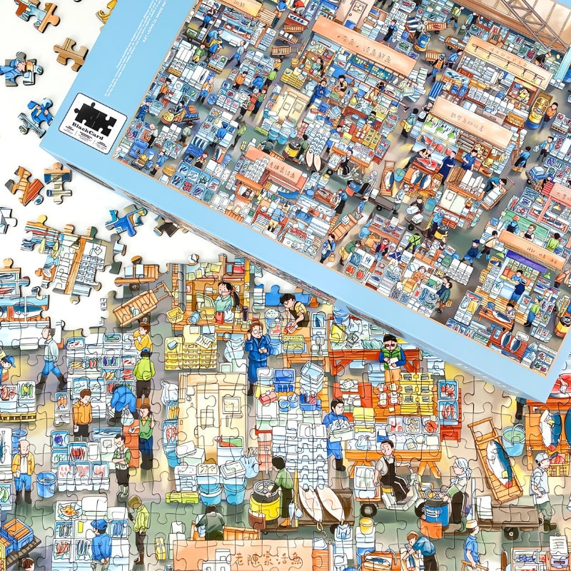 Partially assembled Fish Market puzzle beside its box, showing colourful stalls and characters in a lively market