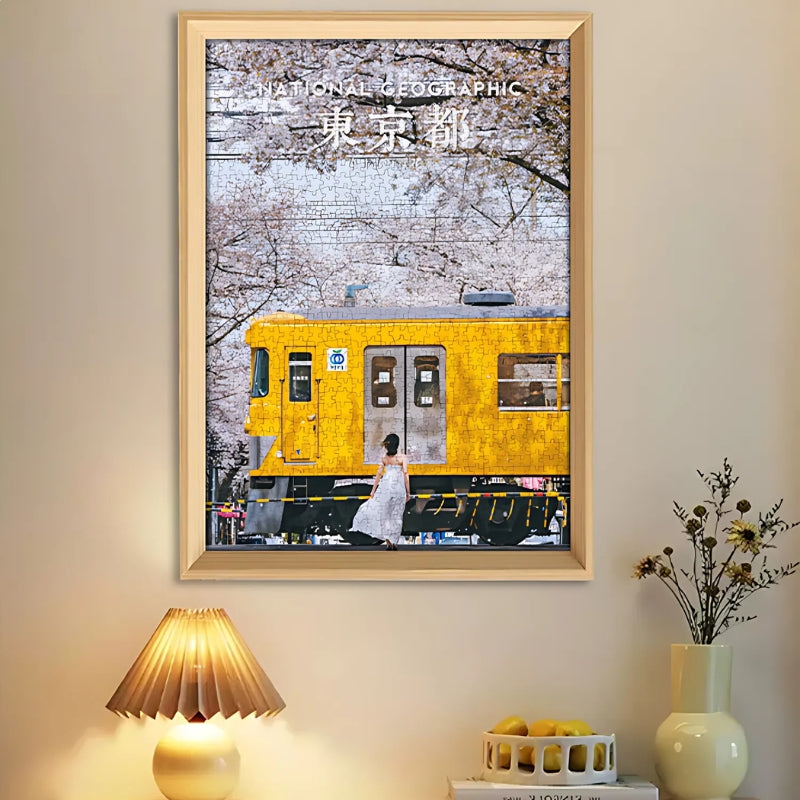 Framed sakura train puzzle displayed on a wall in a warmly lit room