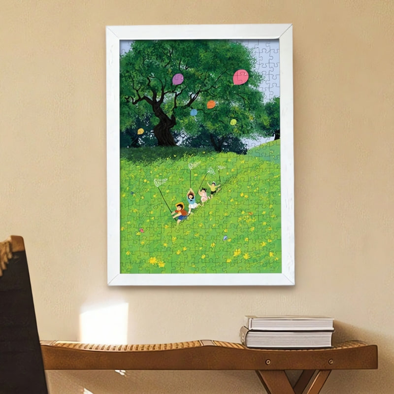Finished puzzle of children and balloons in a bright field, framed on a wall above a table.