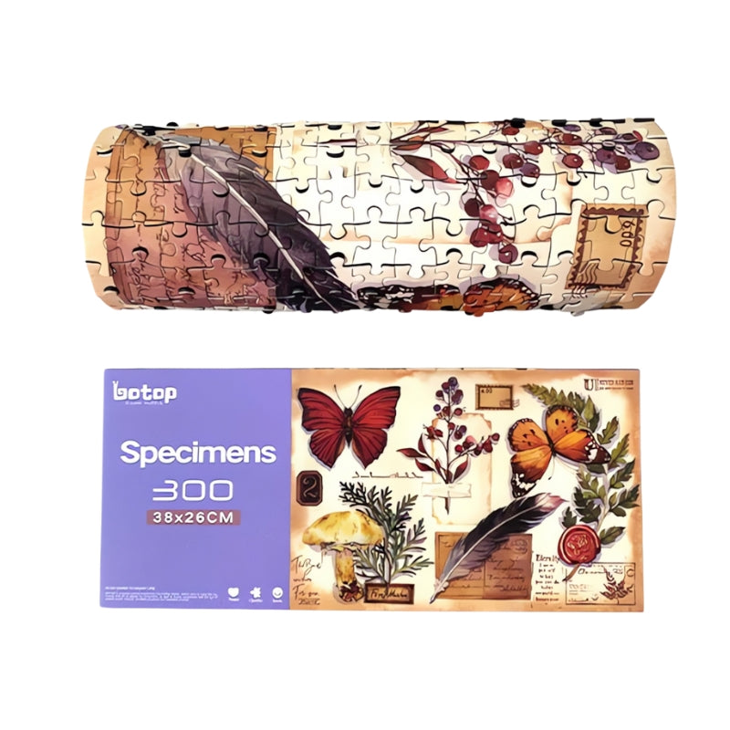 Specimens puzzle box next to the completed puzzle rolled up, displaying botanical and butterfly designs.