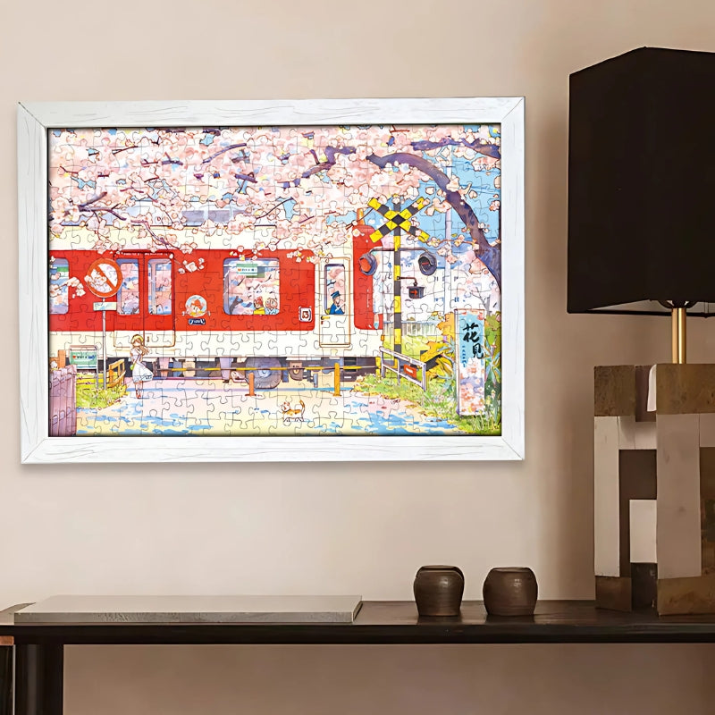 Completed Sakura Train puzzle framed on wall, displaying cherry blossoms, red train, and springtime station