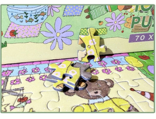 Close-up of puzzle pieces showing the detailed texture and illustration of a bear in pyjamas with floral and pastel surrounding