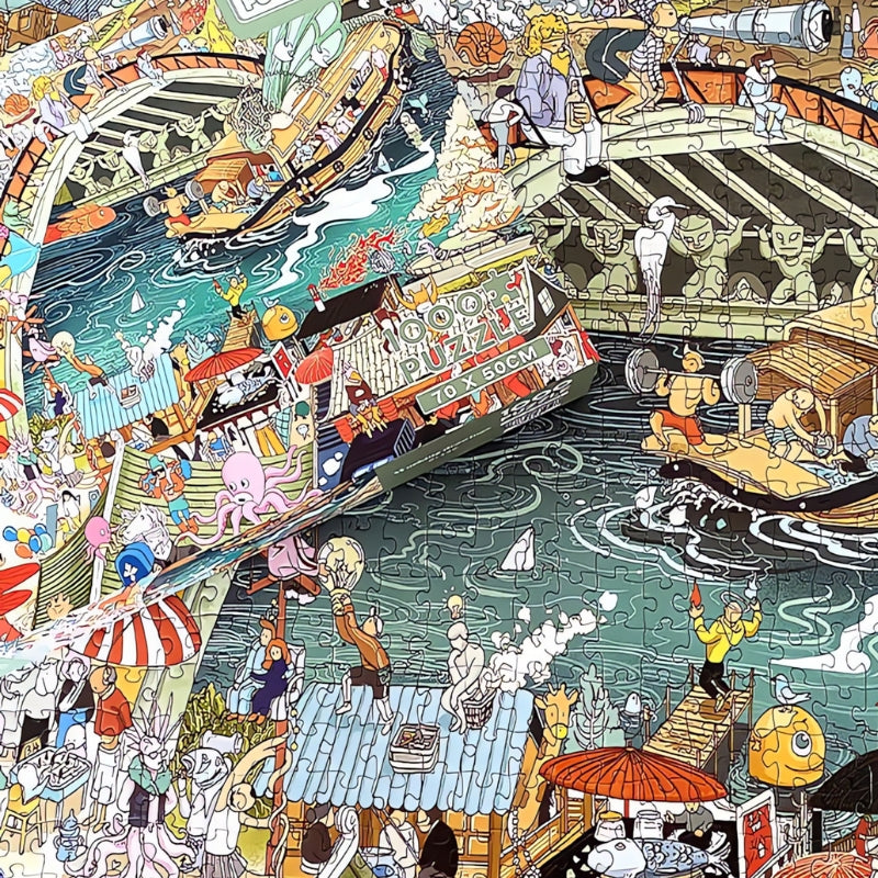 Close-up of assembled Working Drawings puzzle with box placed over vibrant riverside scenes and tiny figures.