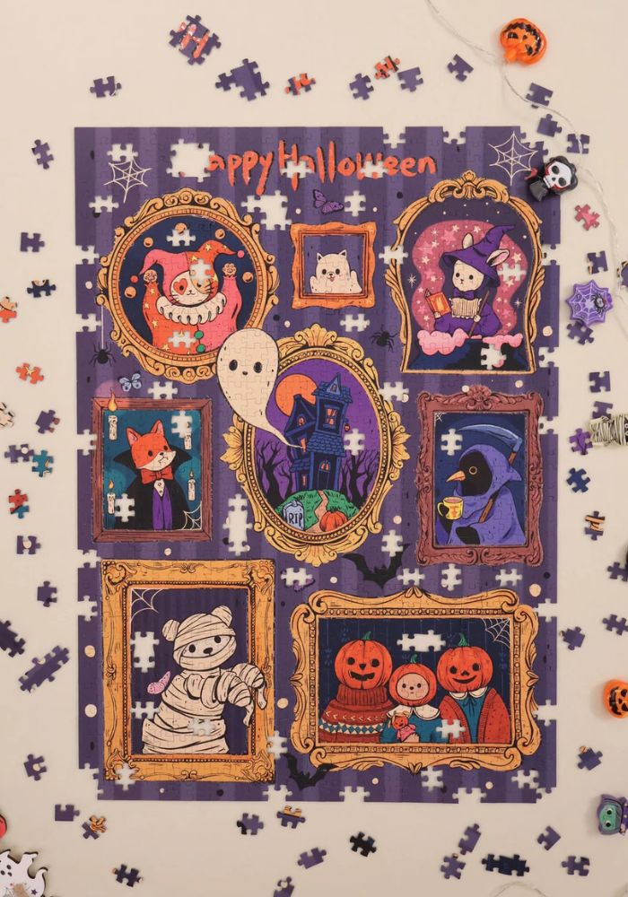 Partially assembled “Feel The Spooky” puzzle on a table with scattered pieces around.