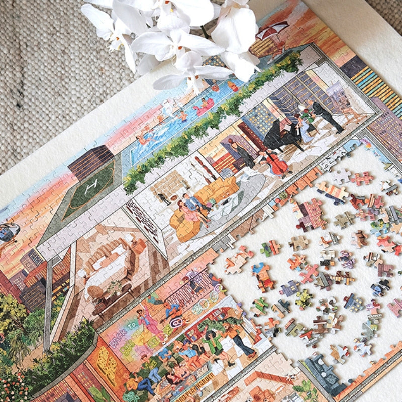 Close-up of PERMA ‘My Aspiration Modern Life’ puzzle partially assembled with scattered loose pieces and white flowers.