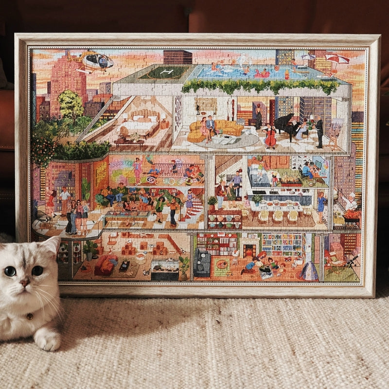 Framed PERMA ‘My Aspiration Modern Life’ 1000-piece puzzle leaning on a wall next to a curious gray cat.