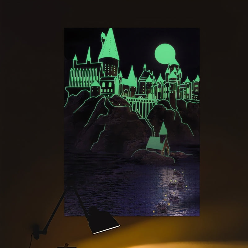 Glow-in-the-dark Harry Potter puzzle showing Hogwarts Castle illuminated at night with moonlight and boats on the Black Lake.
