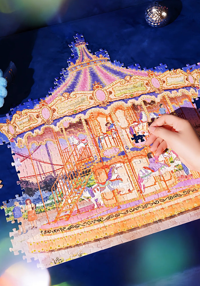Hand placing a puzzle piece onto the nearly completed Starlit Carousel puzzle.
