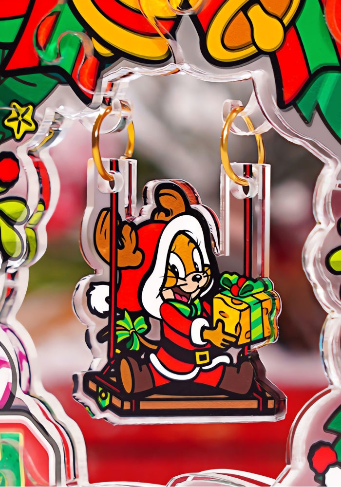Close-up of Jerry in a Santa outfit sitting on a swing, holding a gift, as part of the Christmas Wreath acrylic puzzle.
