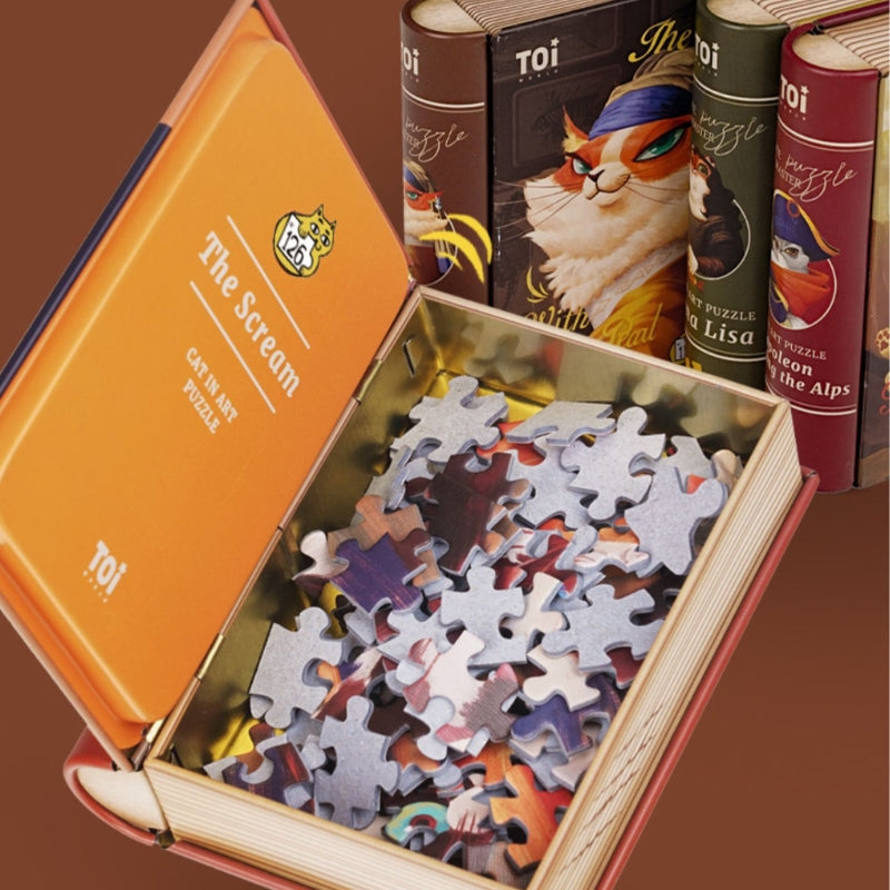 Open book-style box for The Scream cat art puzzle by TOI, showing puzzle pieces inside.