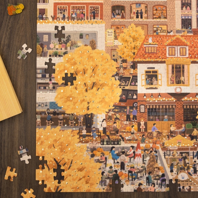 Partially completed Autumn Day puzzle showing golden autumn trees and town buildings.