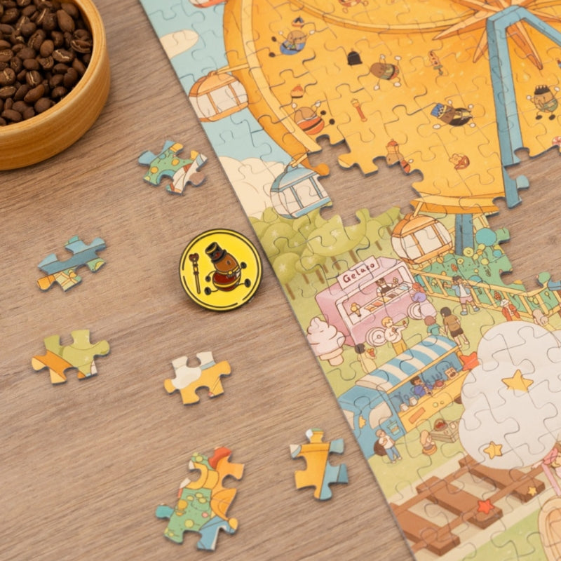 Close-up of puzzle pieces with enamel coffee-themed pin and Ferris wheel artwork.