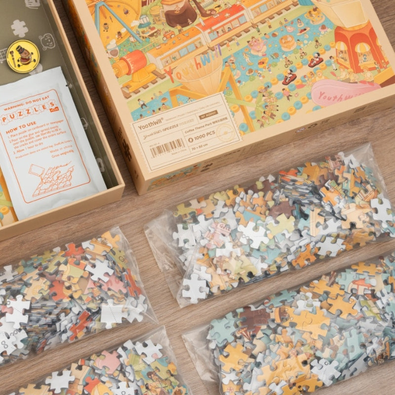 Open box with puzzle glue, enamel pin, and sealed puzzle bags.