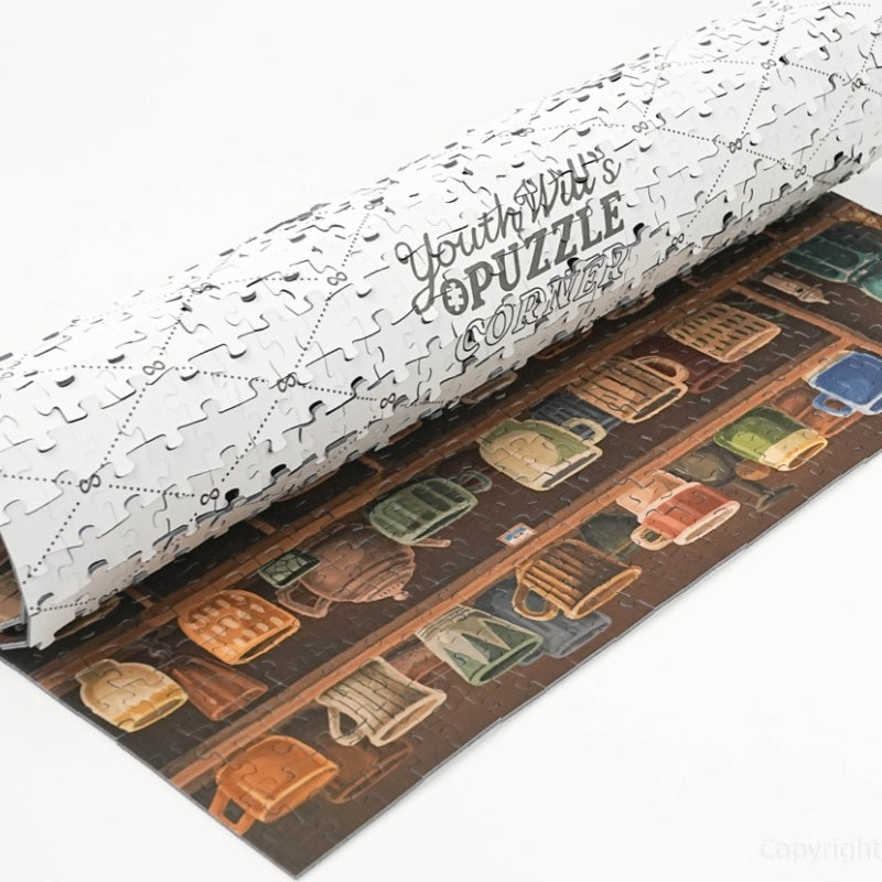 Rolled puzzle mat with partially completed More Coffee Please jigsaw.