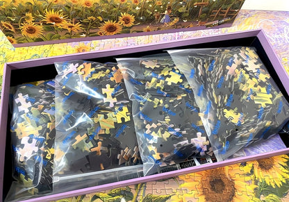 Open puzzle box showing separated bags of sunflower-themed puzzle pieces.