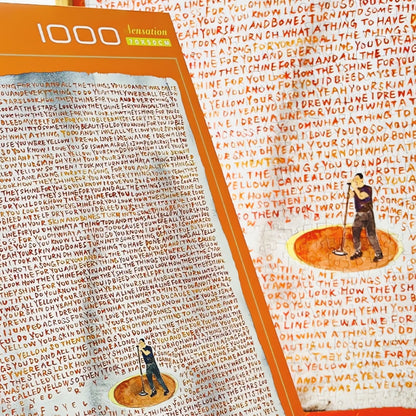 Close-up of Yellow puzzle and box with handwritten song lyrics in red and orange
