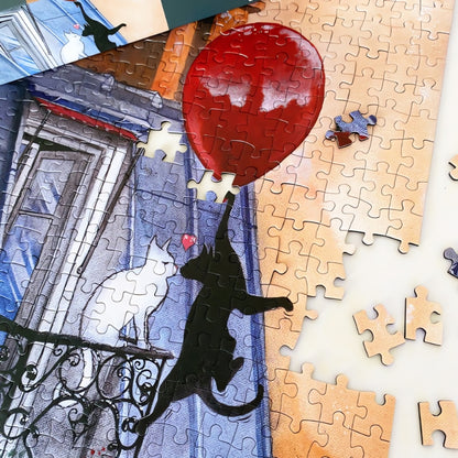 Partially completed Cat Love puzzle with red balloon and black cat reaching toward a white cat