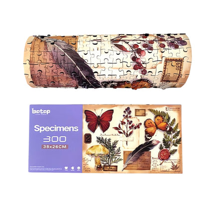 Specimens puzzle box next to the completed puzzle rolled up, displaying botanical and butterfly designs.