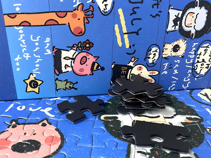 Close-up of Good Day puzzle pieces with cartoon characters and text, alongside stacked black-backed pieces
