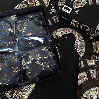 Open puzzle box with sorted bags and a partially completed stained glass cat puzzle underneath