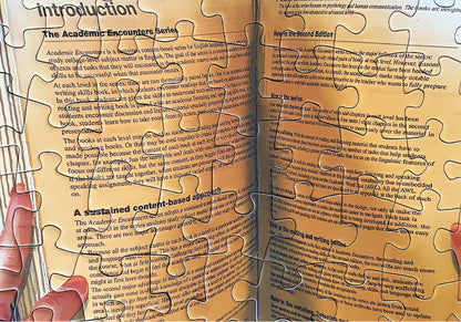 Zoomed-in view of the book in the puzzle showing printed English text and hands holding it