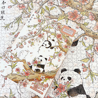Spring Day puzzle box placed over assembled cherry blossom puzzle with pandas