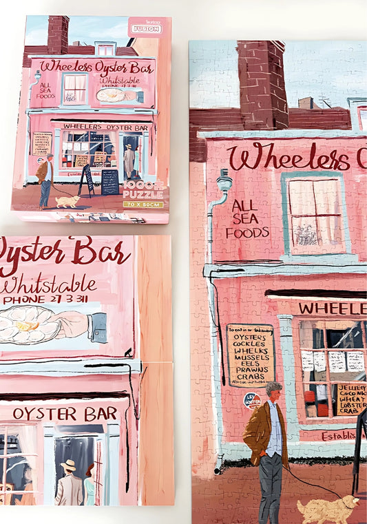 Completed Pink Café jigsaw and box side by side – seaside town puzzle.