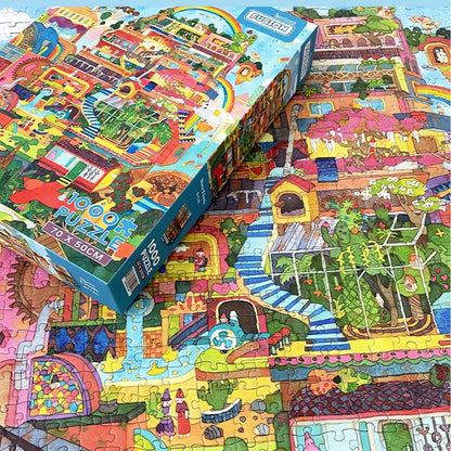 Above Clouds puzzle box resting on finished puzzle with stairways, trees and detailed fantasy buildings.