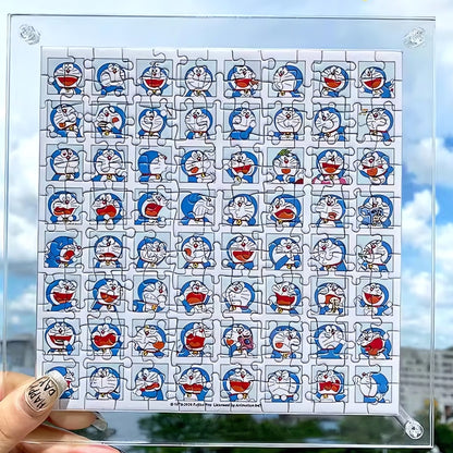 Assembled Doraemon mini puzzle held against the sky, showing a grid of Doraemon facial expressions.