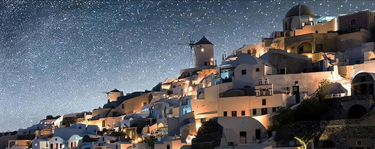 Santorini puzzle with glowing hillside homes and windmills beneath a starry sky.