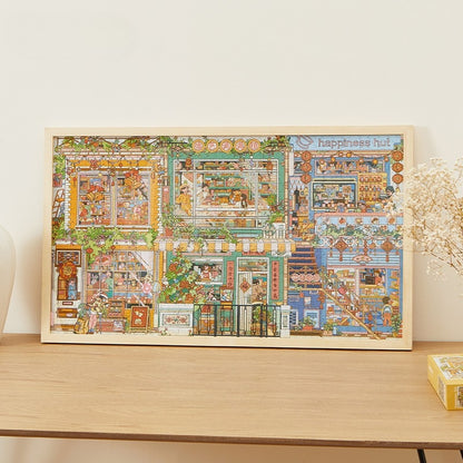 Framed completed Happiness Hut Keytime jigsaw puzzle on wooden sideboard, featuring colourful houses and shops.