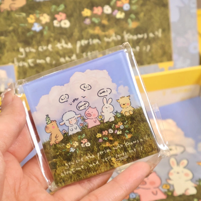 Hand holding included fridge magnet featuring the same animal friends illustration.