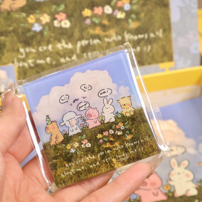 Hand holding included fridge magnet featuring the same animal friends illustration.