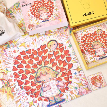 Overhead shot of the completed “Love Out Loud” puzzle with its box, magnet, and packaging accessories.