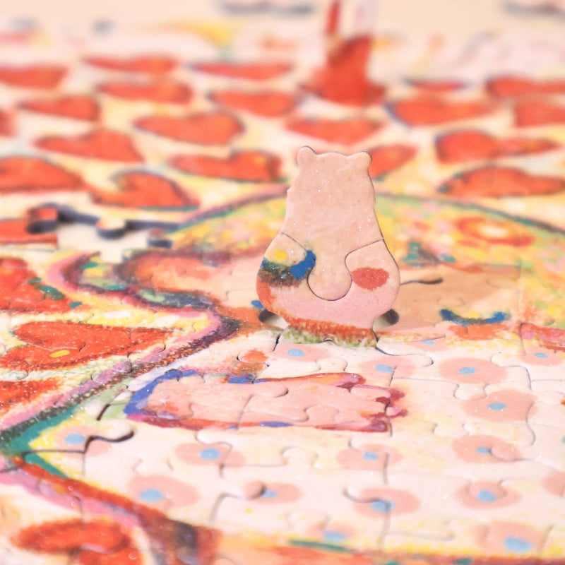 Close-up of a uniquely shaped bear puzzle piece standing upright on the puzzle.