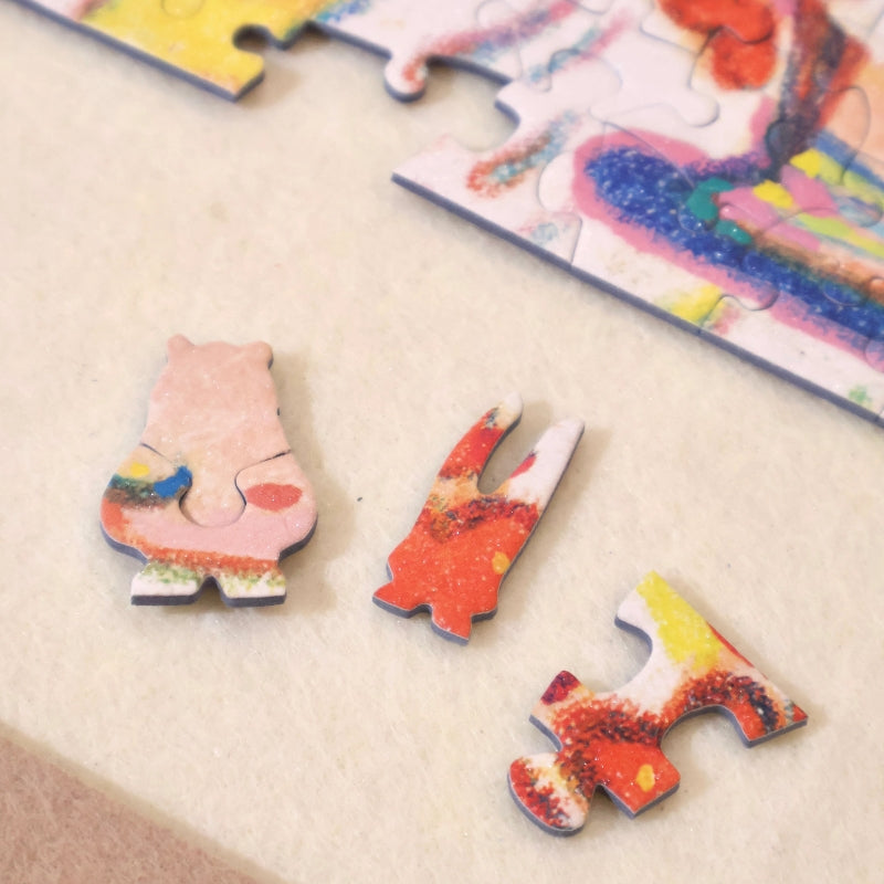 Three unique puzzle pieces — bunny ears, standard piece, and bear — displayed on a felt mat near the puzzle edge.