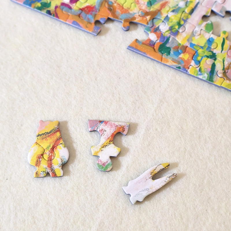 Close-up of three special-shaped puzzle pieces laid out on a cream background.