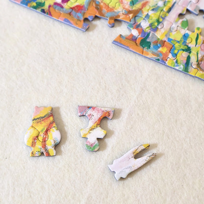 Close-up of three special-shaped puzzle pieces laid out on a cream background.