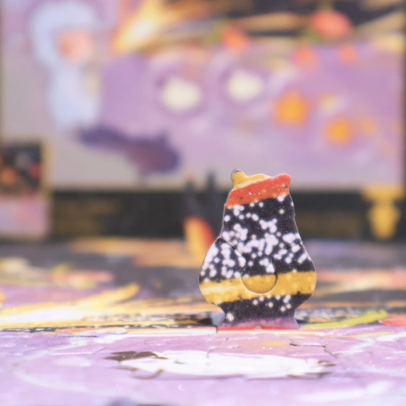 Close-up of a special-shaped puzzle piece standing upright on the assembled jigsaw, designed with a galaxy-inspired pattern.