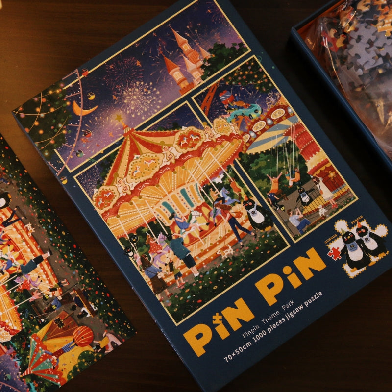 Box and puzzle pieces of Pinpin Theme Park 1000 piece set displayed on table.