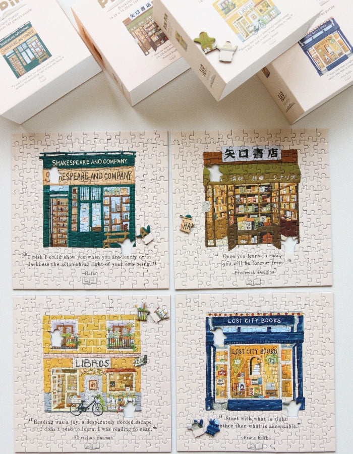 Flat lay of framed bookstore puzzles including Libros, Shakespeare & Company, Lost City Books, and others.
