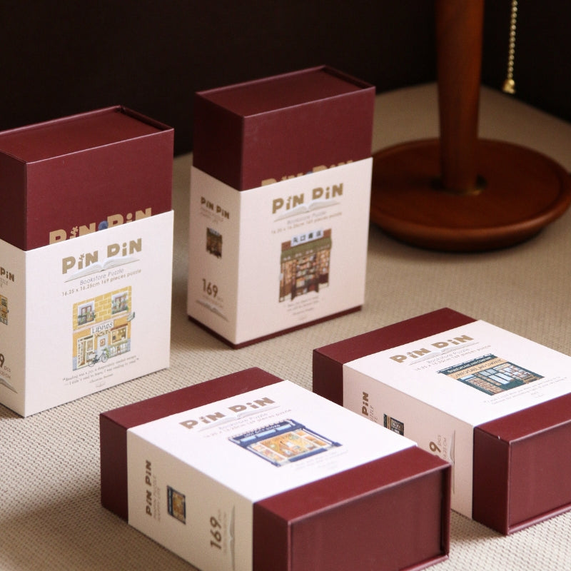 Set of Pin Pin Mini Bookstore puzzles in maroon and cream boxes, collectible bookish puzzle series.