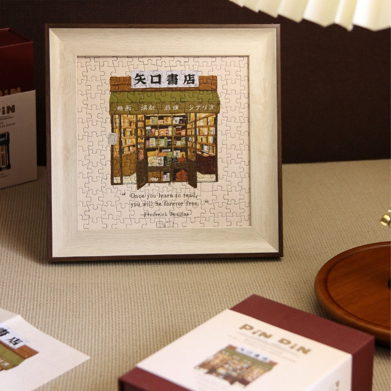 Framed completed Yaguchi Book Store mini puzzle displayed on table.