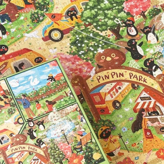 Pinpin Garden Party jigsaw puzzle in progress with vibrant details of park entrance, penguins, and cherry blossom trees.