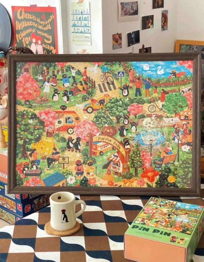 Completed Pinpin Garden Party 1000 piece jigsaw puzzle displayed in a frame showing penguins and friends enjoying a garden festival.