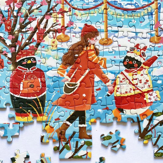 Close-up detail of Pinpin Ice Sculpture Exhibition puzzle showing penguins in red winter coats and festive decorations.
