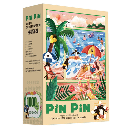 Pinpin Sunshine Coast 1000 piece puzzle box featuring vibrant beach artwork with penguins, palm trees, and ocean waves.